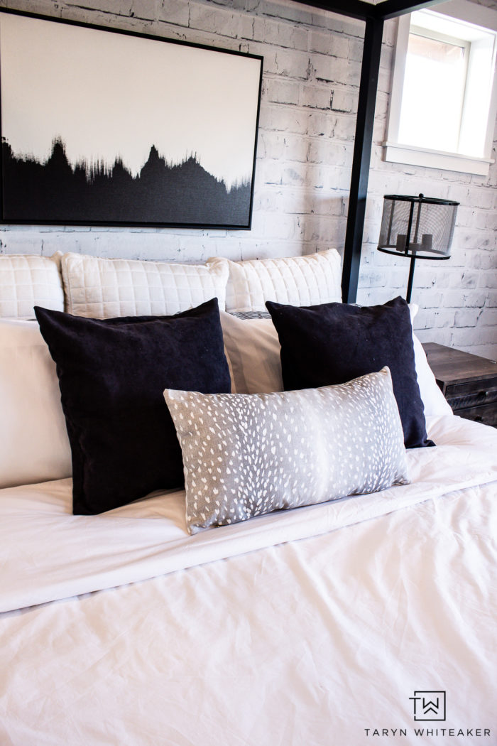 Black and white bedroom decor with antelope accent pillow and rustic touches. 