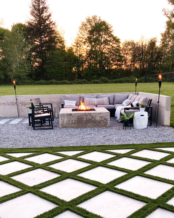 Backyard landscape design with concrete fire pit and modern outdoor space complete with grid style turf. 