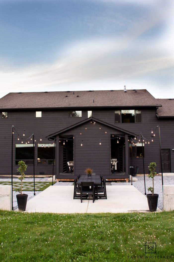 Black Exterior with neutral backyard design and string lights 