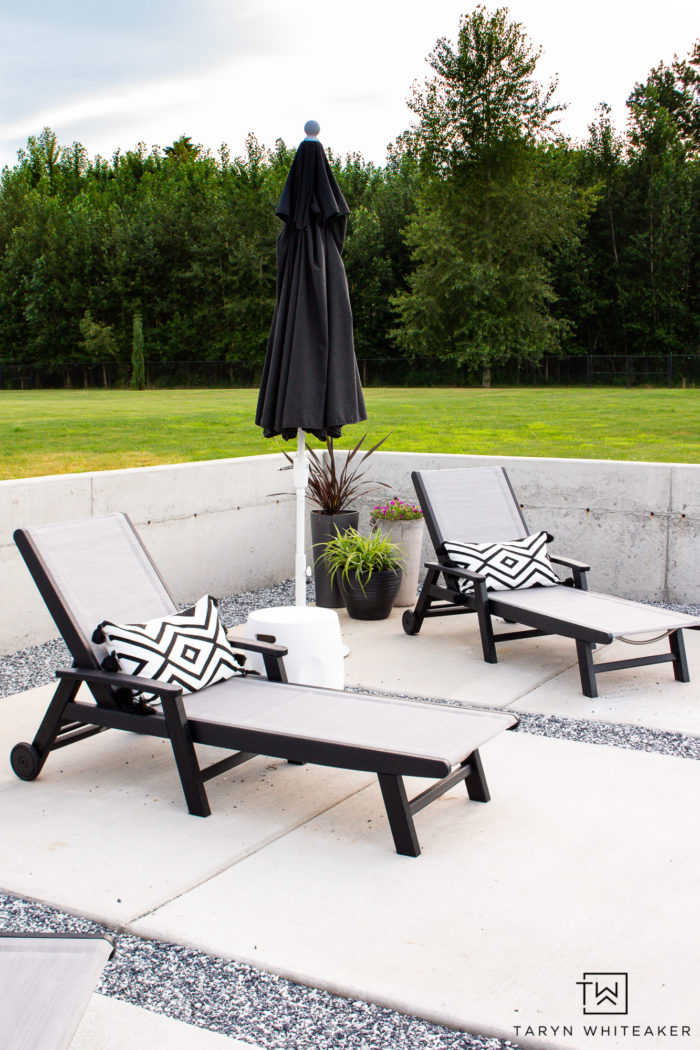 Check out this backyard lounging area with modern chaise lounges and sun umbrella. The black and white are a classic look. 