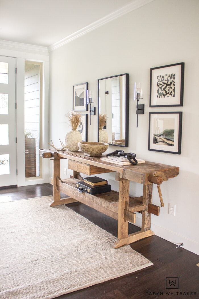 Rustic Modern entry way with vintage carpenters table console and fine art prints 