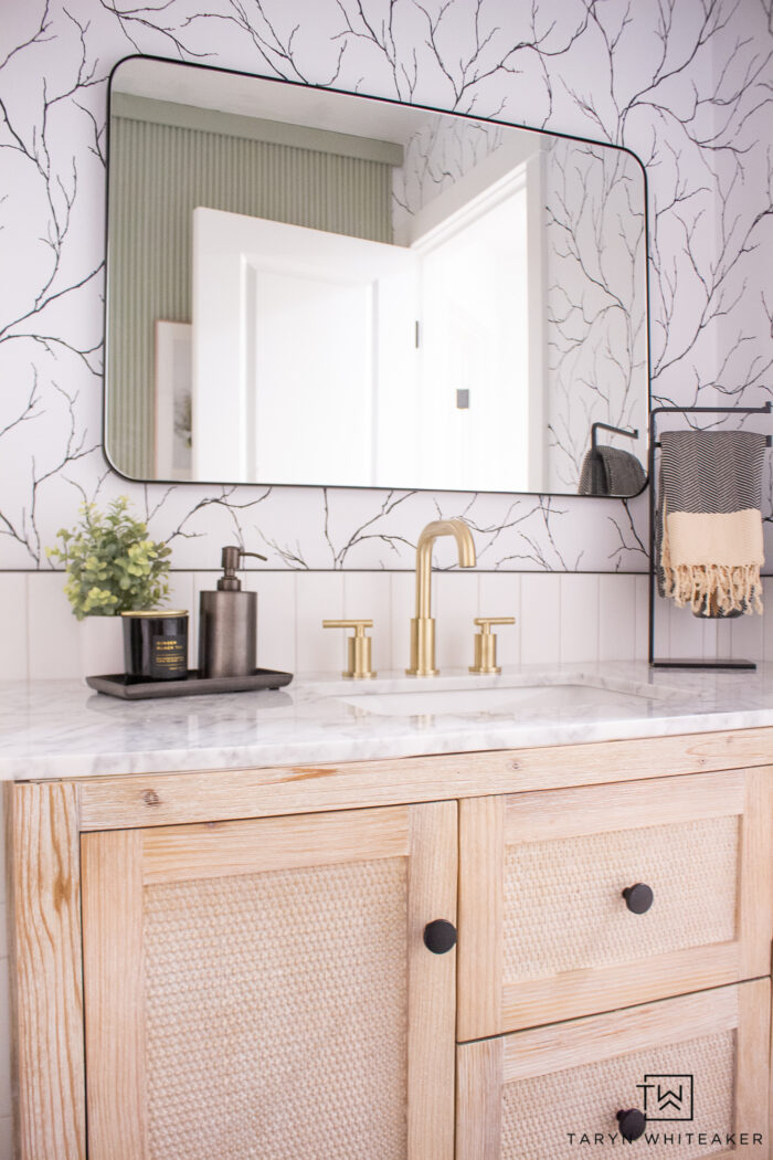 First peek of the Black and White Bathroom Vanity with rattan vanity, hexagon floor and half wall subway tile. 