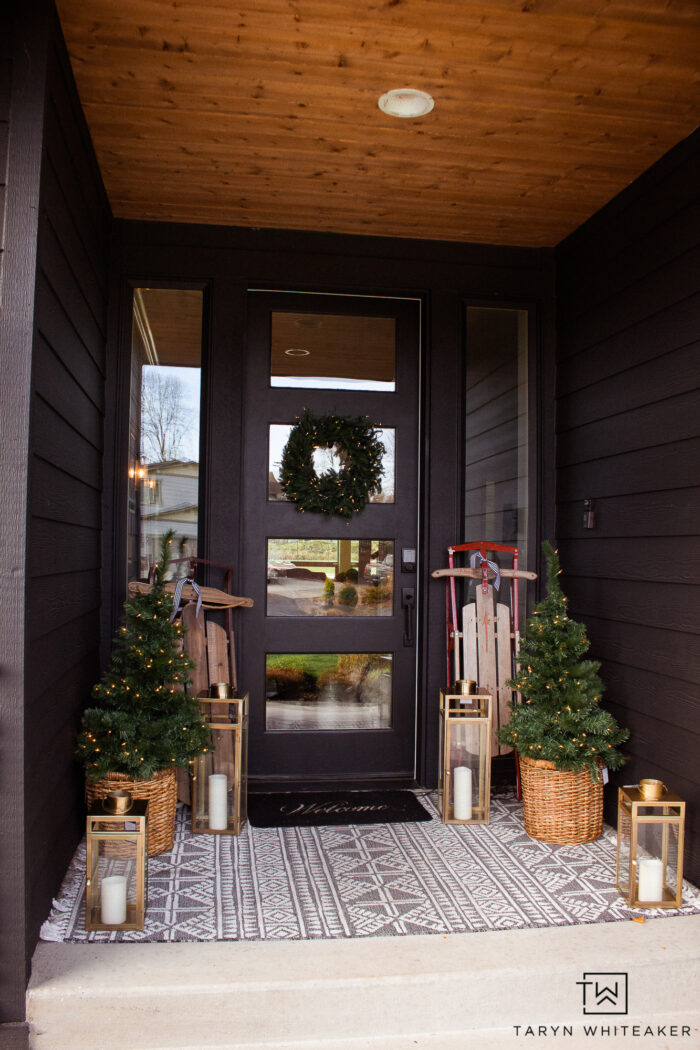 Get the look of this Classic Holiday Porch with greenery, vintage sleds and brass lanterns that add a glow. Love how it pops against the dark exterior. 