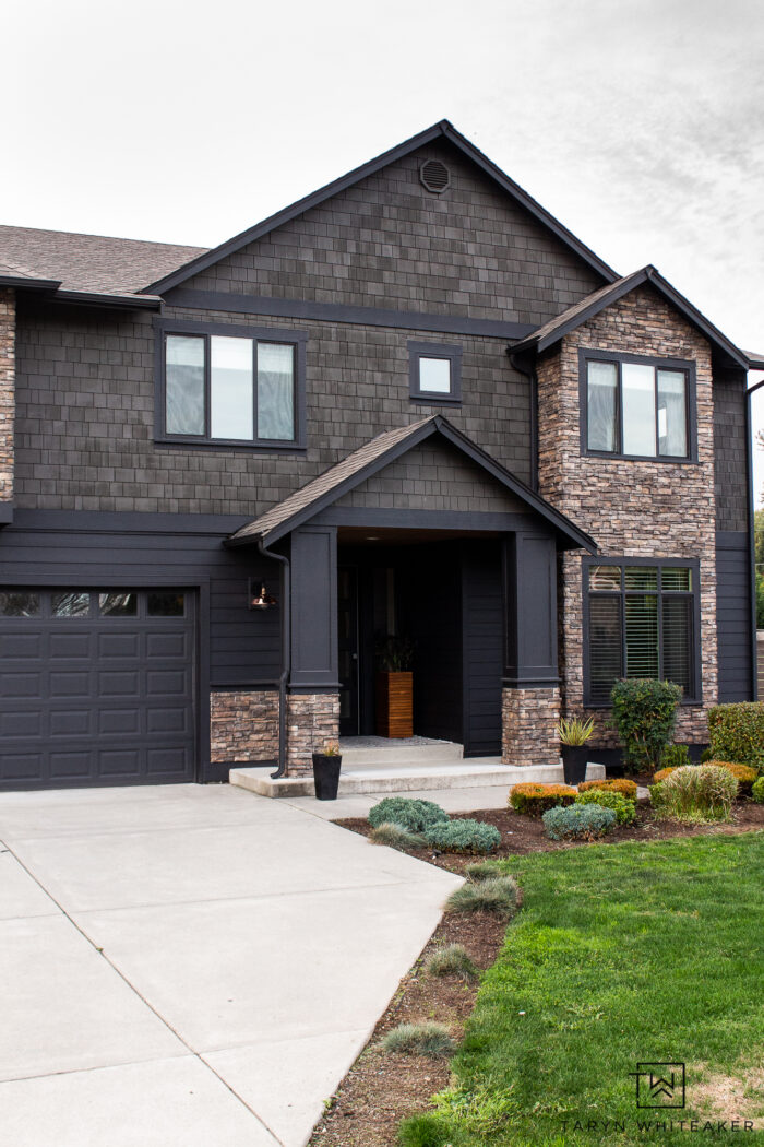 black exterior with stained shingles and stacked stone accents 