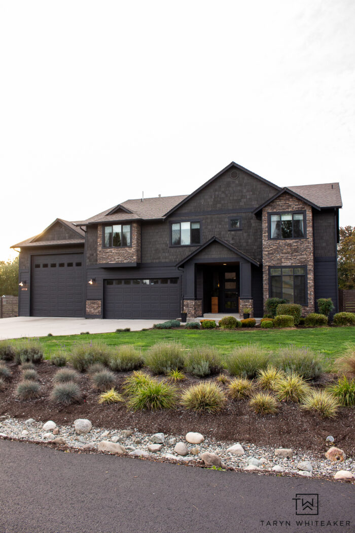 Dark Home Exterior Makeover with landscaped drainage ditch with dry stream