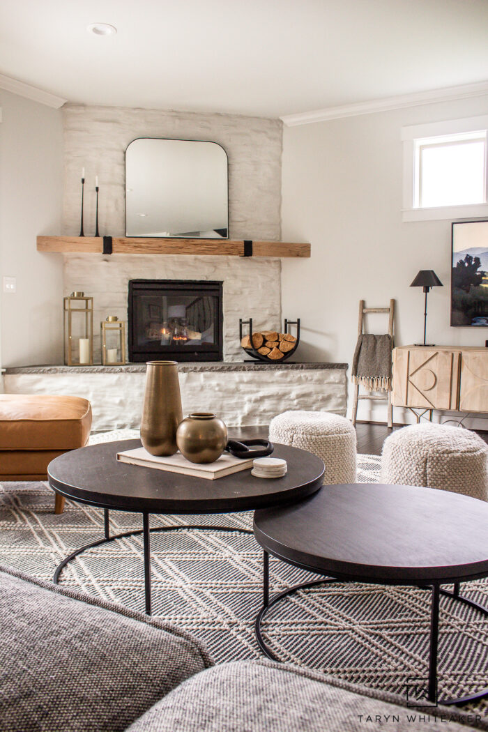 Monochromatic living room design with light stone fireplace and wood accents