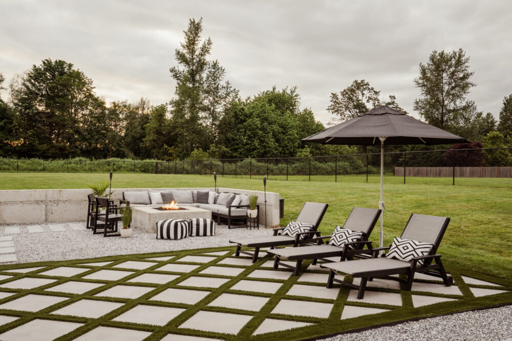 Large scale modern outdoor fire pit with square concrete fire pit and cozy sectional. PaverTurf design for modern look. 