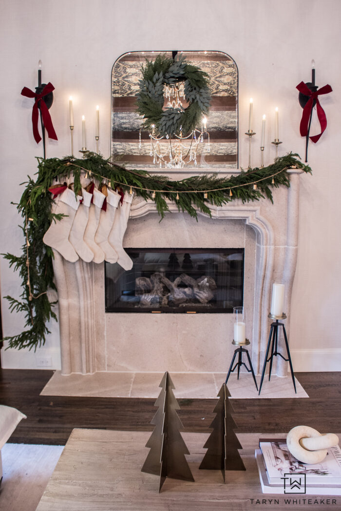 Get the look of this European Inspired Christmas Mantel by twisting multiple garlands together and adding brass candles with pops of red. 