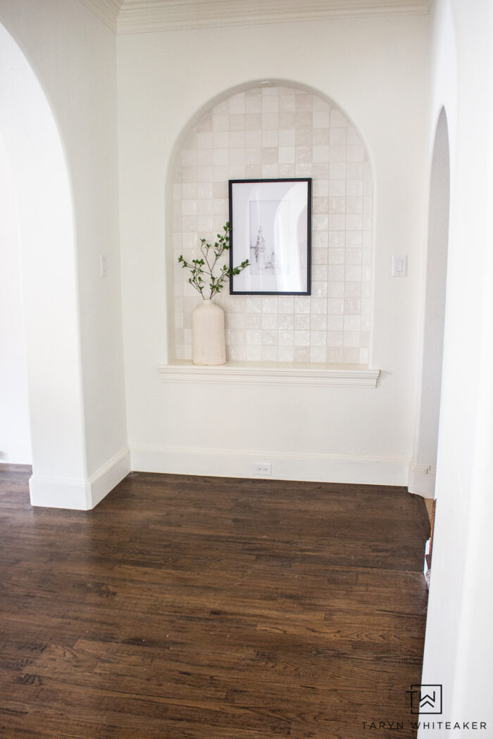 Tiled arched wall niche styled with artwork and greenery