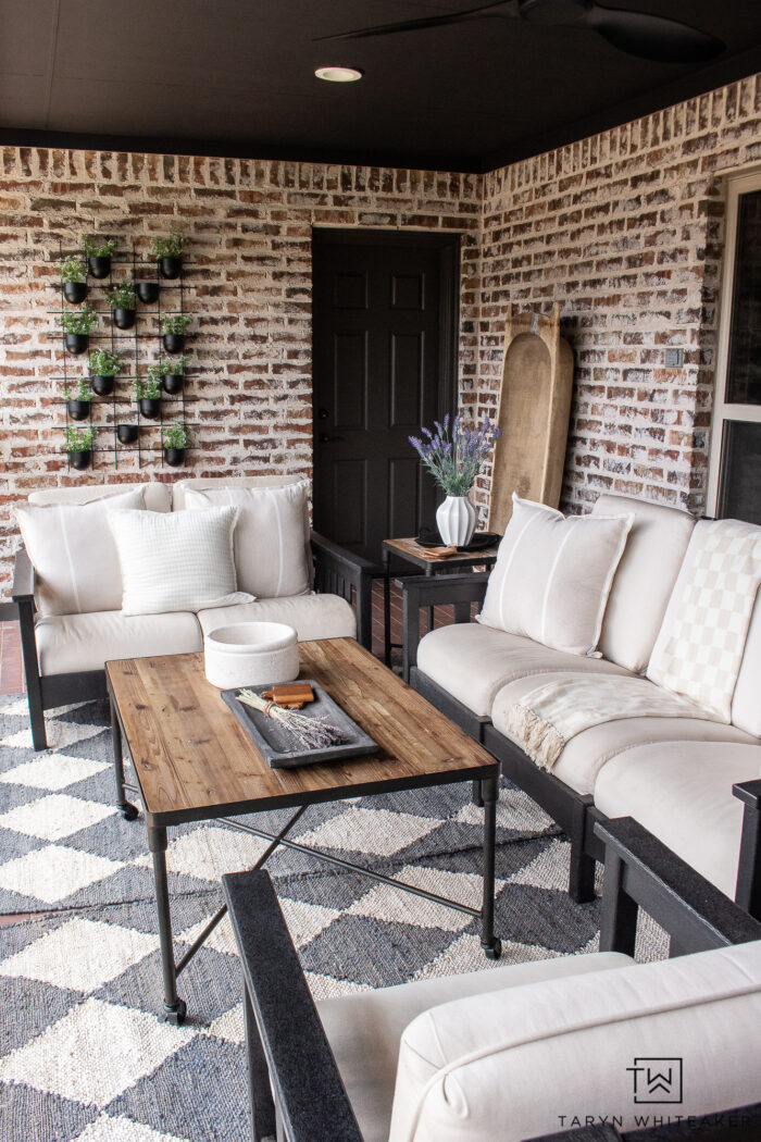 Brick patio made into a modern space with Urbane Bronze door and trim, painted French doors, black POLYWOOD furniture, rustic coffee table and a mixture of both modern and vintage elements. 