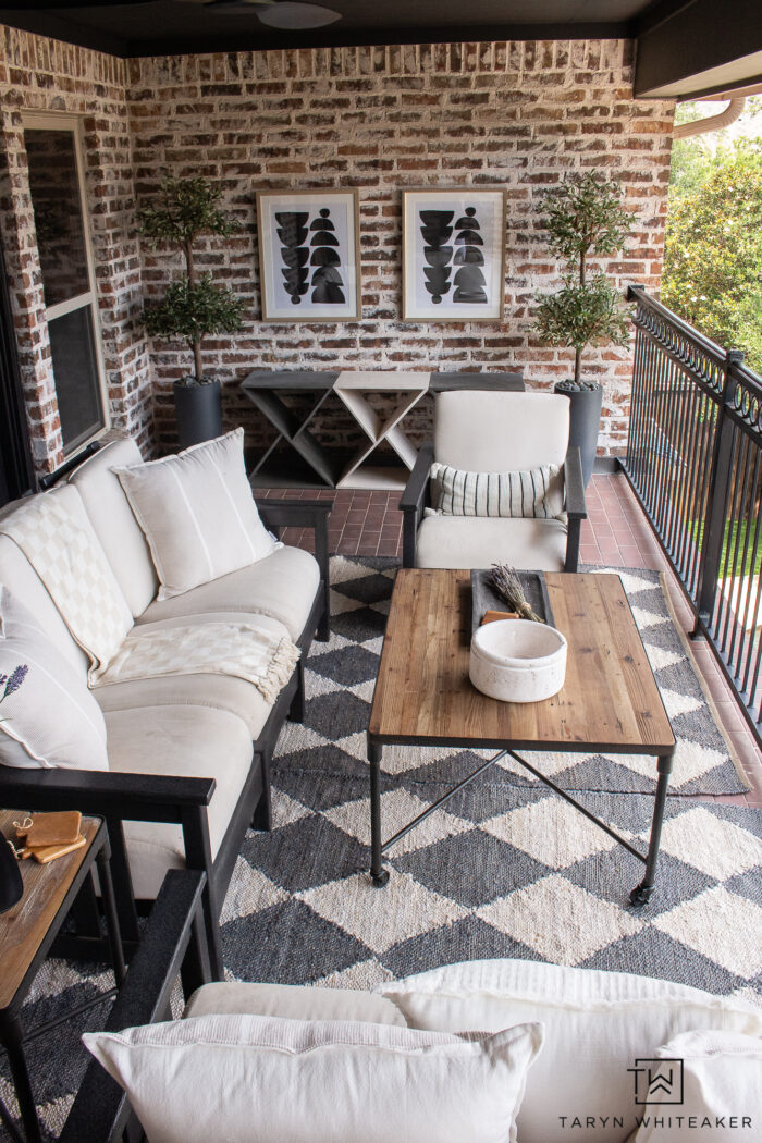 Take your traditional patio to the next level by decorating it with modern transitional decor. Add artwork against the brick walls and olive topiaries. 