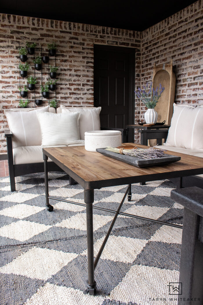 Brick patio made into a modern space with Urbane Bronze door and trim, painted French doors, black POLYWOOD furniture, rustic coffee table and a mixture of both modern and vintage elements. 