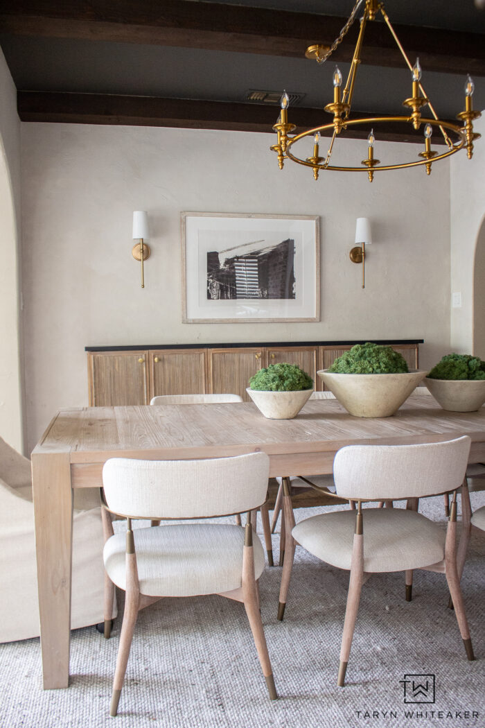 Modern organic dining room decor with white washed rustic dining table, upholstered captains chairs, fluted buffet