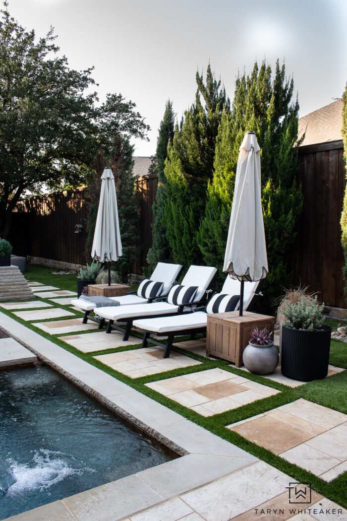 Black and white outdoor lounge chairs with scalloped umbrellas and modern planters. 