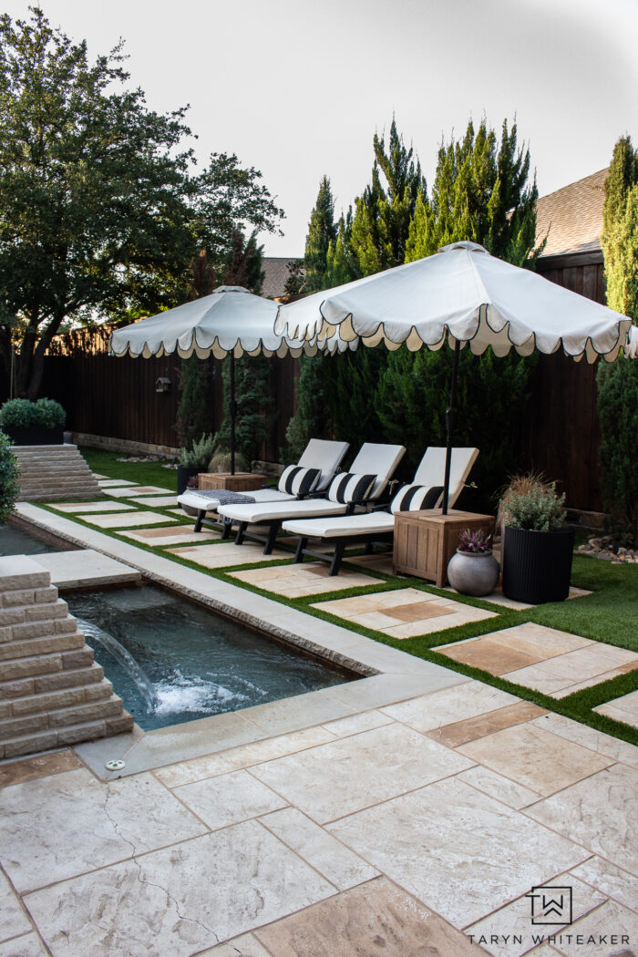 Tour this Modern English Country Backyard featuring classic black and white outdoor furniture and decor with greenery and brick exterior. 