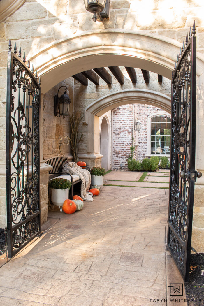 Cozy fall bench display with cozy blanket, corn stalks, heirloom pumpkins and mums. The perfect simple fall entry display. 