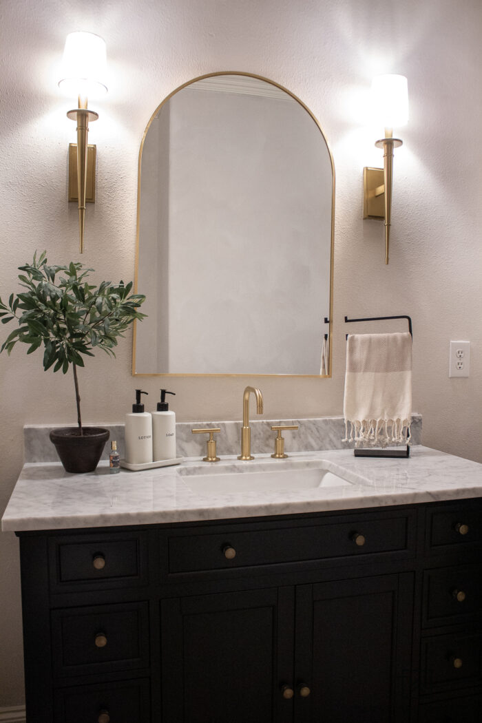 transitional powder room vanity decor with brushed gold accents and off white walls. 