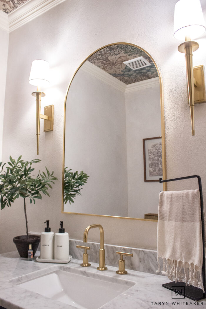 transitional powder room vanity decor with brushed gold accents and off white walls. 