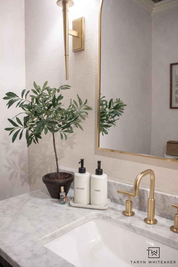 transitional powder room vanity decor with brushed gold accents and off white walls. 