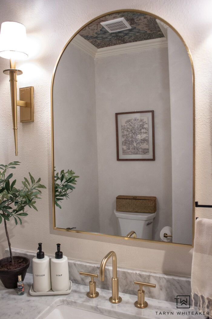 transitional powder room vanity decor with brushed gold accents and off white walls. 