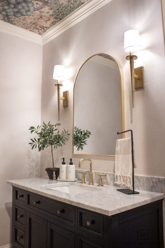 transitional powder room vanity decor with brushed gold accents and off white walls. 
