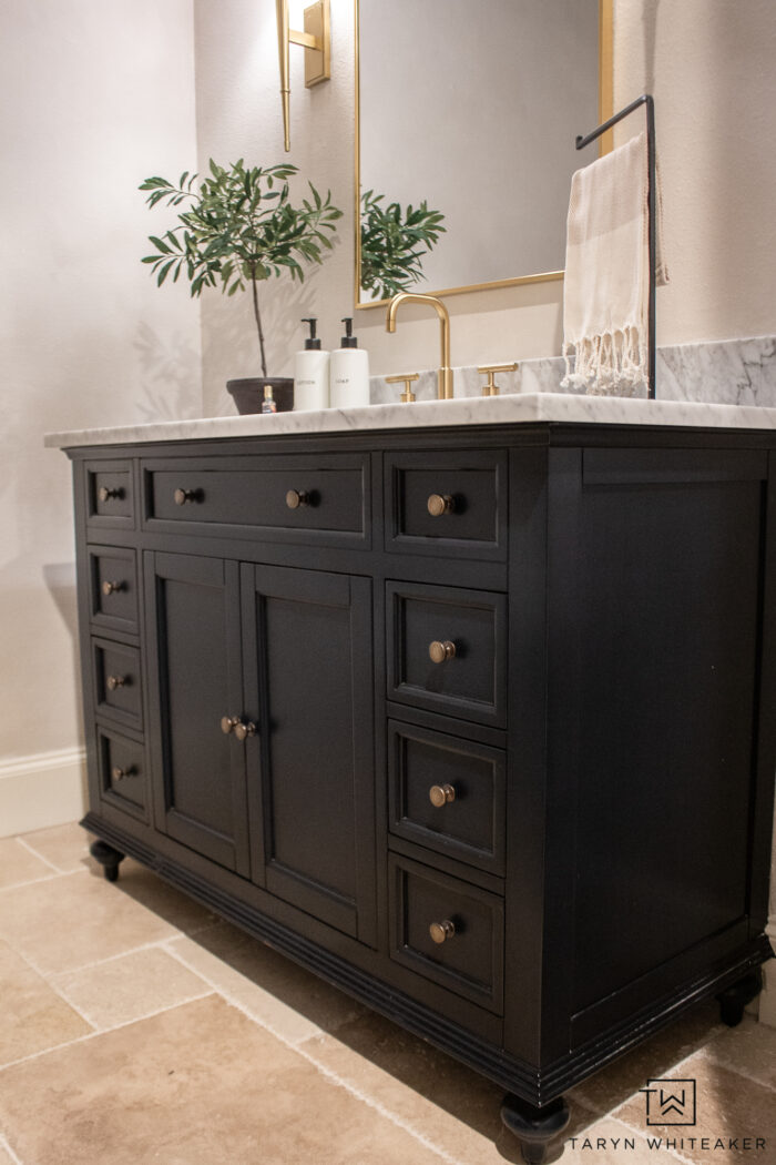 transitional powder room vanity decor with brushed gold accents and off white walls. 