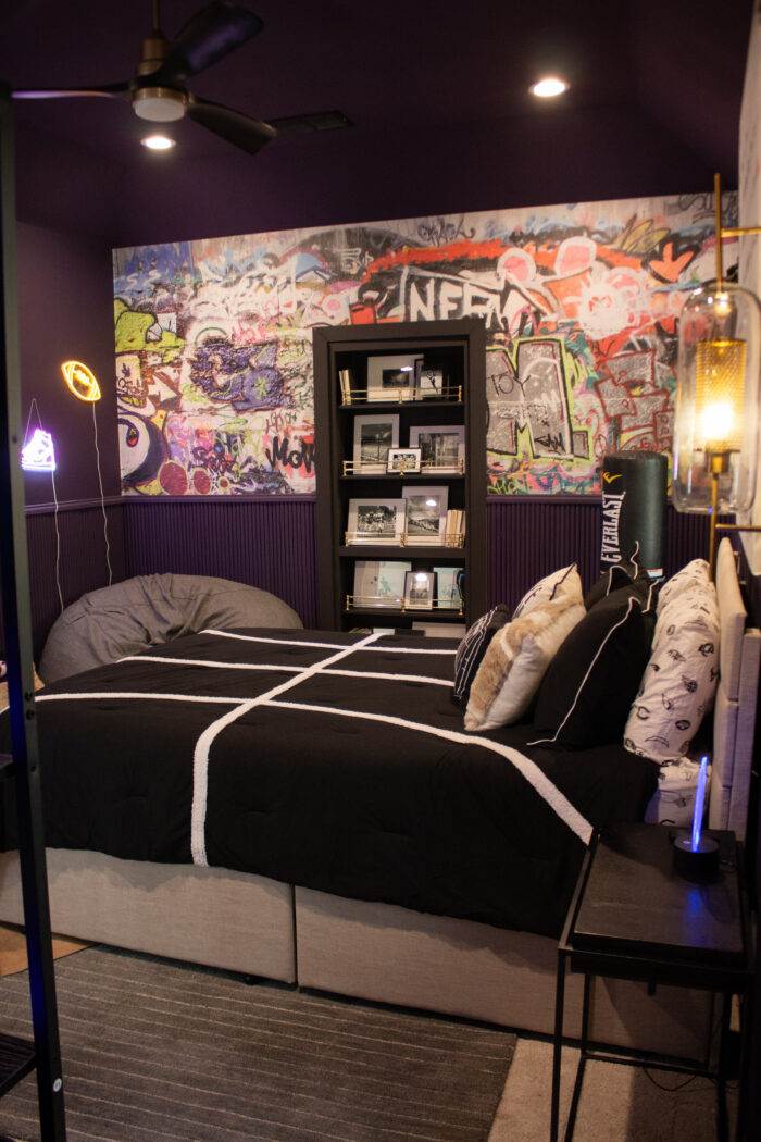 Tour this Teen Bold Sports Bedroom Design with rich purple walls and black accents. Teen football and sports themed bedroom. 