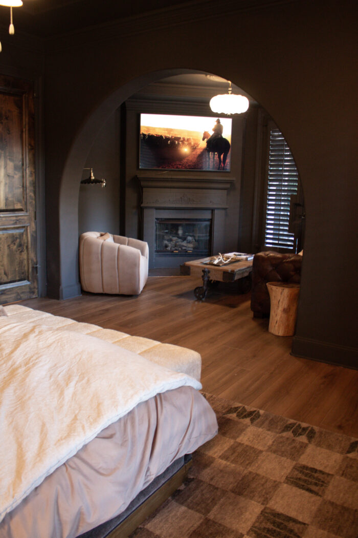 dark brown bedroom walls with brown leather sofa and dark fireplace seating area
