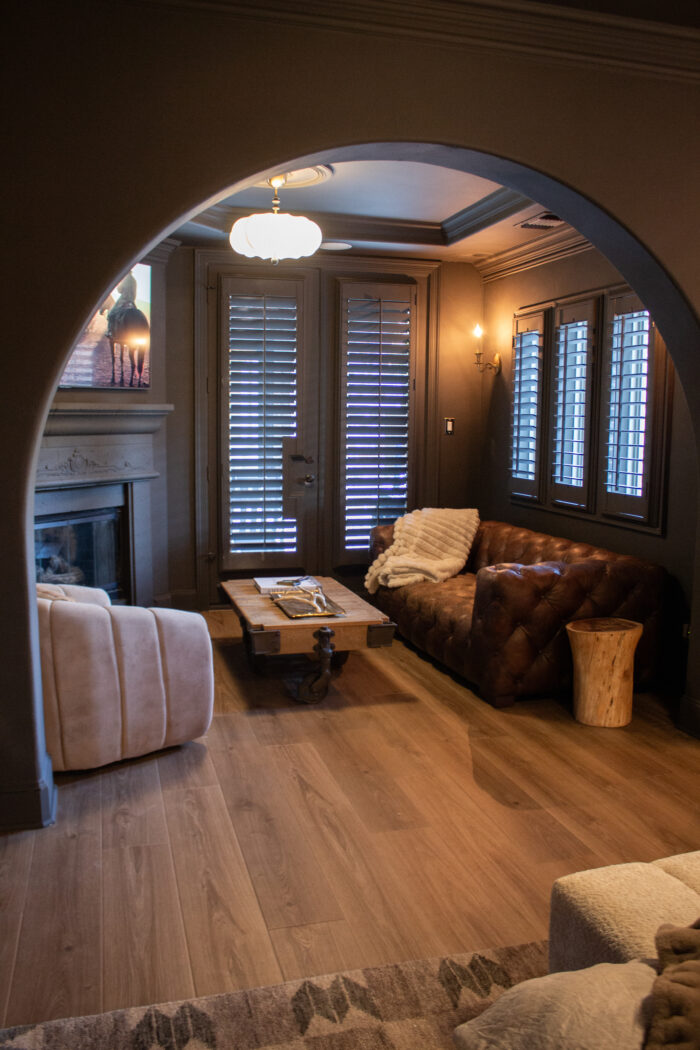 dark brown bedroom walls with brown leather sofa and dark fireplace seating area